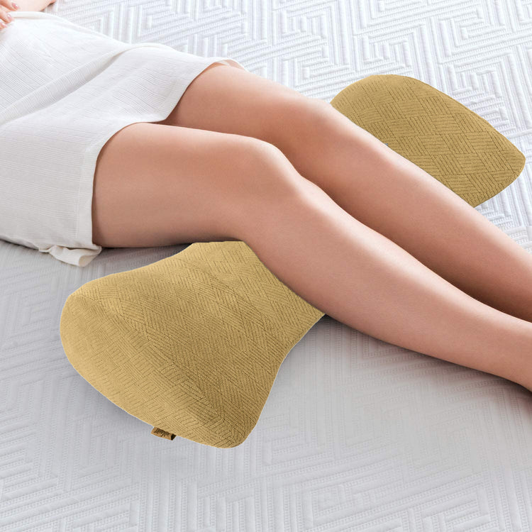 Person lying on a white mattress with the Livingful Premium Wedge Reading Pillow positioned between their knees, providing support and alignment.